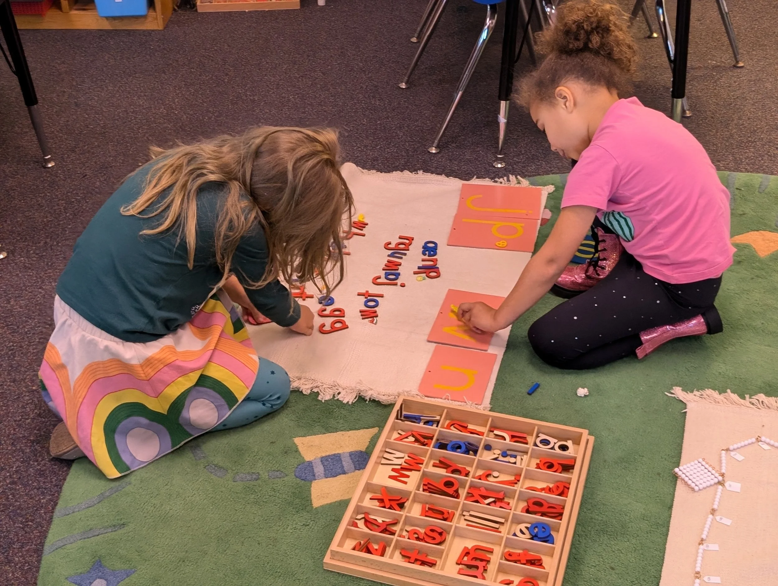 Learners collaborating with Montessori materials