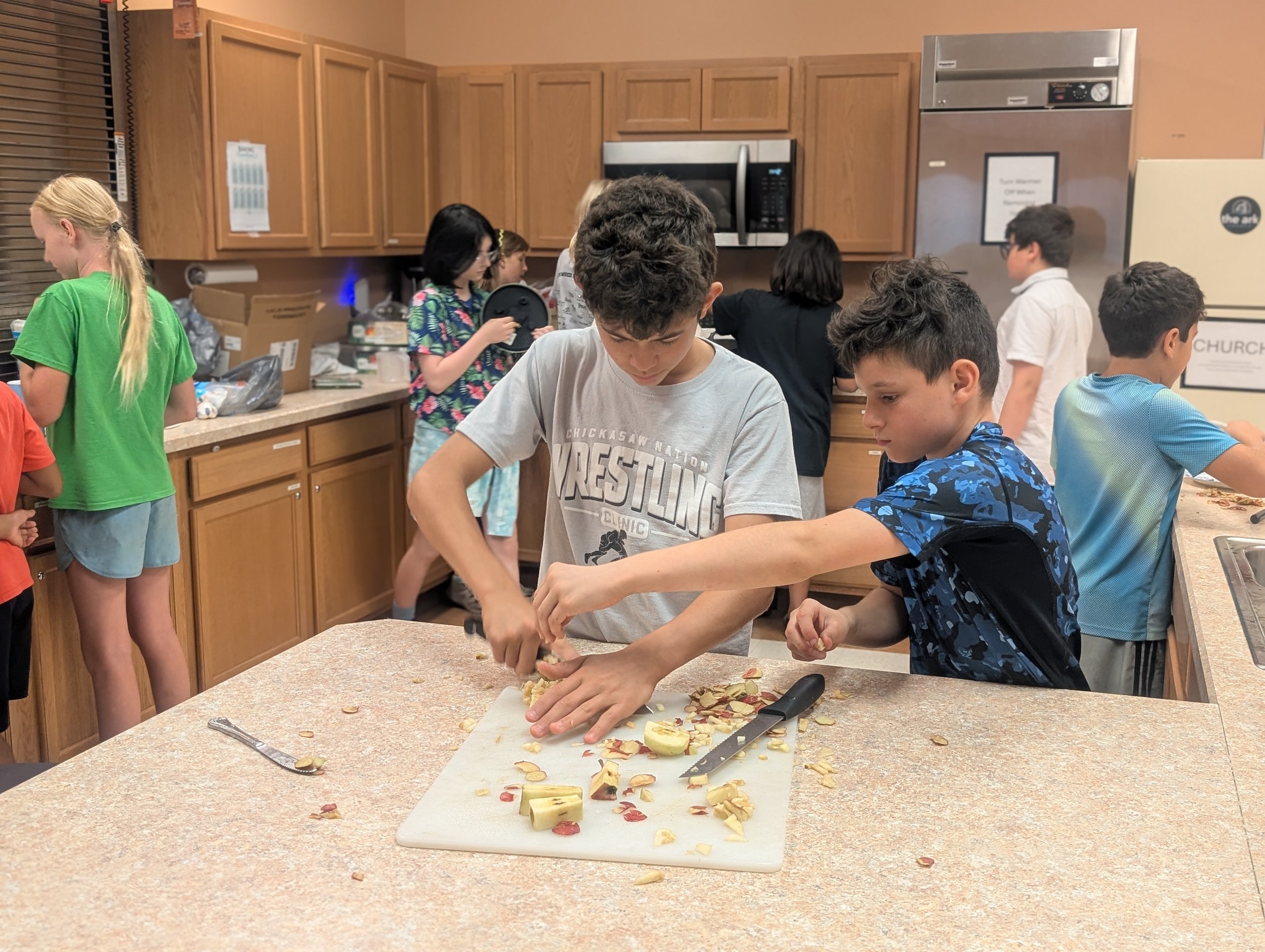Microschool students in Dublin, OH working in the kitchen making apple cider